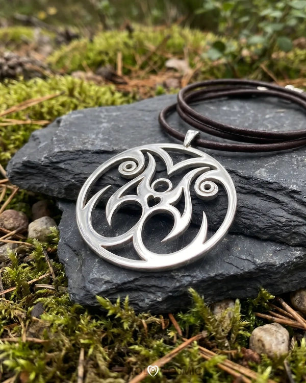 Colgante cósmico espiritual y visionario Shaeim en plata, tumbado sobre una roca. Joyería alquímica de HoloCosmic.